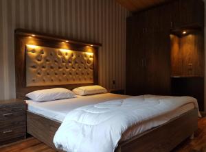 - une chambre avec un grand lit éclairé dans l'établissement Panjkura Hotel And Resorts, à Tāl