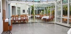 a dining room with tables and chairs and windows at Albhotel Fortuna in Riederich