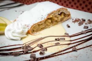 a piece of pie sitting on a plate with a fork at Hotel Ramon in Campitello di Fassa