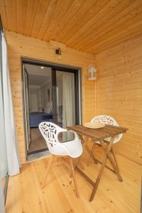 een houten kamer met een tafel en 2 stoelen bij Casa Caravela - Vale de Lourinhã in Praia da Areia Branca