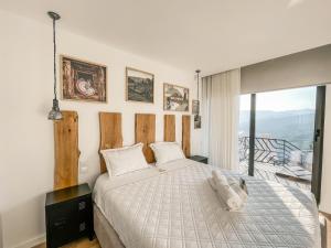 a bedroom with a large bed and a balcony at Encosta de Louredo by Pousadela Village in Vieira do Minho +188 photos
