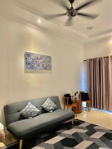 a living room with a couch and a ceiling fan at HnR HOMESTAY PORT DICKSON in Port Dickson