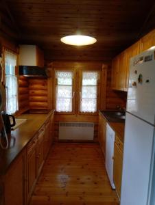 a kitchen with wooden cabinets and a white refrigerator at Chalet de Llivia in Estavar +9 photos