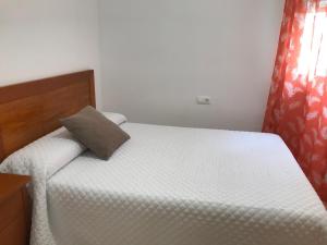 - une chambre avec un lit et un oreiller dans l'établissement Apartamento Playa Grau Moncofa, à Moncofa