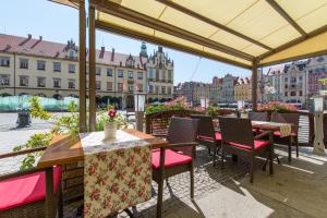 a patio with tables and chairs and a view of a city at Hotel Dwór Polski in Wrocław