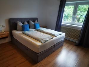 a bedroom with a bed with blue pillows on it at Ferienwohnung Solebad in Gmünd
