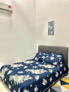 uma cama num quarto com um cobertor azul em HnR HOMESTAY PORT DICKSON em Porto Dickson