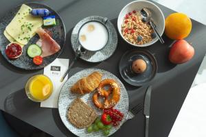 a table topped with plates of breakfast foods and drinks at the niu Brass in Munich