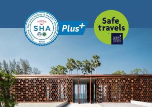 un bâtiment avec un panneau indiquant des voyages sûrs dans l'établissement The Naka Phuket, a Member of Design Hotels - SHA Extra Plus, à Kamala Beach