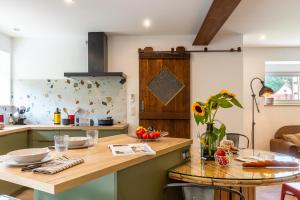 a kitchen with a wooden counter and a table at La Pause Verdoyante in Moosch