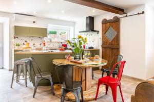 cocina con mesa de madera y sillas en La Pause Verdoyante, en Moosch