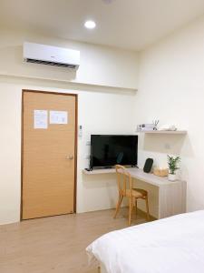 Un dormitorio con una cama y un escritorio y una puerta. en Cozy Homestay, en Tainan 36 fotos más