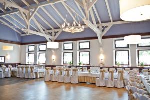 uma configuração para um casamento em uma grande sala com mesas e cadeiras em Zajazd Mat em Bełk