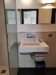 bagno con lavandino e specchio di Suite210 a Trani