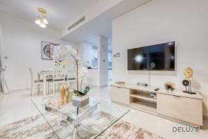 TV a/nebo společenská místnost v ubytování Delightful 3BR Townhouse at DAMAC Hills 2 Dubailand by Deluxe Holiday Homes