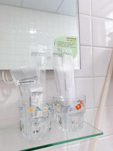 dos recipientes de plástico transparente sentados en una estantería de vidrio en Cozy Homestay, en Tainan
