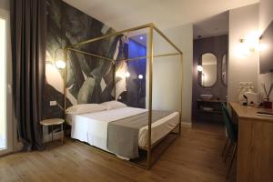 阿格里真托Krysos Luxury Rooms的卧室里有一张床，墙上挂着一幅画