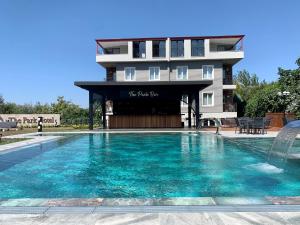 a hotel with a swimming pool in front of a building at Istanbul Park Hotel in Tuzla
