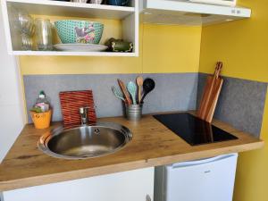 - un comptoir de cuisine avec évier et quelques ustensiles dans l'établissement La Cabane de Lili Prune, à Goudargues