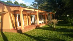 a house with a porch and a grass yard at Maison du Bonheur in Sainte Marie