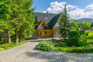 a house with a stone driveway in front of it at Willa Sosna in Kościelisko