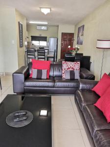 sala de estar con sofá de cuero marrón en Ann's Place en Umdloti