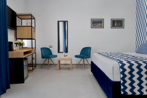 um quarto com uma cama e duas cadeiras azuis em HSuites Luxury B&B em Castellammare di Stabia