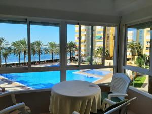 a table and chairs in a room with a view of a pool at Apartamentos Intercentro Algarrobo-Costa APARTAMENTOS TURÍSTICOS -INMOBILIARIA in Algarrobo-Costa