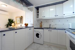 ロザスにあるLEON INMO Apartment Panoramica - 11095のキッチン(白いキャビネット、洗濯機、乾燥機付)