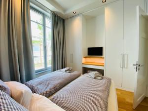 two beds in a room with a tv and a window at Strandvilla Charlotte Binz in Binz
