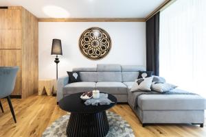 ein Wohnzimmer mit einem Sofa und einem Tisch in der Unterkunft Bogdańskiego Residence in Zakopane