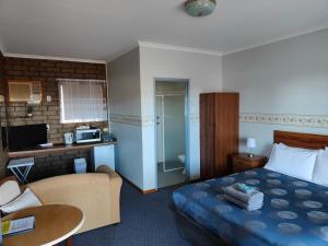 Airport Whyalla Motel في وايالا: غرفه فندقيه بسرير وحمام