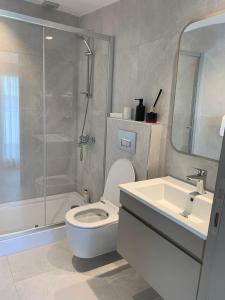 a bathroom with a shower and a toilet and a sink at Istanbul Park Hotel in Tuzla