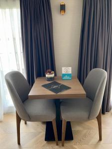 a wooden table with two chairs and a box on top at Istanbul Park Hotel in Tuzla
