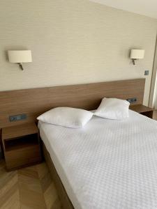 a bedroom with a bed with two pillows and two lamps at Istanbul Park Hotel in Tuzla