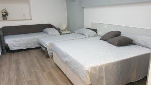 sypialnia z 2 łóżkami i kanapą w obiekcie A DUE PASSI BED & BREAKFAST w mieście Troia