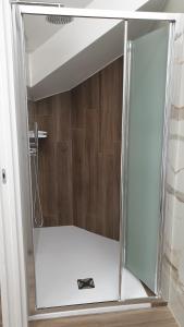 y baño con ducha y puerta de cristal. en A DUE PASSI BED & BREAKFAST, en Troia