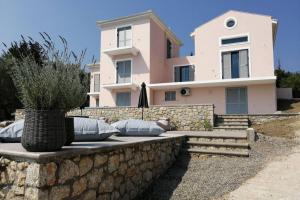 a house with pillows sitting on a stone wall at LAURA_SEA VIEW_APARTMENT 2 in Lygia