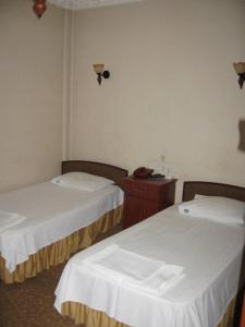 a hotel room with two beds and a phone on the wall at Hotel Atasayan in Gebze