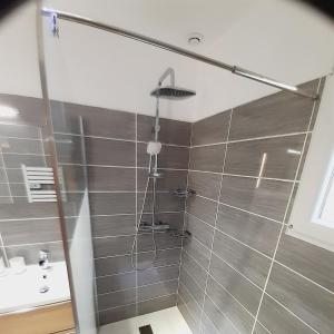 a shower with a glass door in a bathroom at Chambres Privées " Les Pins " in Béziers