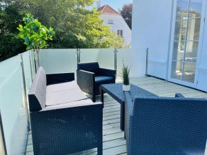 2 chaises bleues en osier et une table sur une terrasse dans l'établissement aday - City Central Mansion - 1 Bedroom with big terrace, à Aalborg