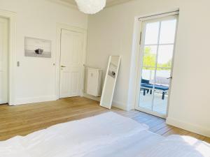 a white room with a bed and a sliding glass door at aday - City Central Mansion - 1 Bedroom with big terrace in Aalborg