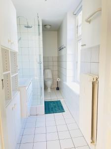 a white bathroom with a shower and a toilet at aday - City Central Mansion - 1 Bedroom with big terrace in Aalborg