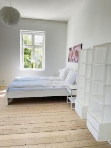 a white bedroom with a bed and a window at aday - City Central Mansion - 1 Bedroom with big terrace in Aalborg