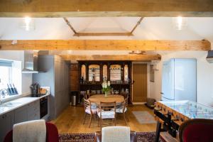 uma cozinha com mesa e cadeiras num quarto em The Cowshed Port Lympne em Hythe