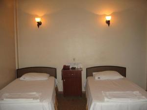 two beds in a room with lights on the wall at Hotel Atasayan in Gebze