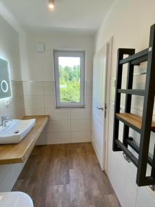 ein weißes Bad mit einem Waschbecken und einem Fenster in der Unterkunft Spreewald - Ferienhaus - Wilhelmine in Burg