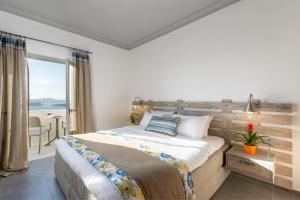 a bedroom with a bed with a view of the ocean at Caldera's Dolphin Suites in Megalochori