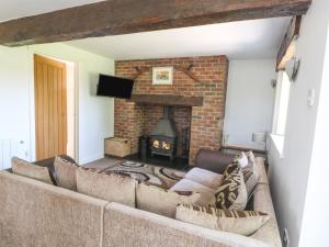 a living room with a couch and a fireplace at Rhosydd Cottage in Llanallgo