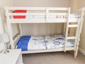 a bunk bed room with two bunk beds at Rhosydd Cottage in Llanallgo